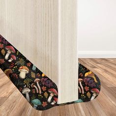 the corner of a room with wood flooring and mushrooms printed on it's side