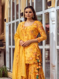 This Set Has Kurta, Gharara & Dupatta. Gorgeous combination of yellow, printed kurta gharara with potli buttons and intricate detailing with matching Chanderi foil print dupatta. Color: Yellow Fabric: Kurta & Gharara- Cotton Silk Dupatta - Chanderi Product Details: Neck Type - Round neck Anarkali Length - 34 inches Bottom Length - 38-40 inches Sleeve Length - 18-19 inches Note: Available in other colors The product will be delivered within 2-4 weeks of order placed Wash Care - Dry clean only Mea Designer Yellow Palazzo Set With Printed Motifs, Designer Yellow Palazzo Set With Chikankari Embroidery, Designer Yellow Chikankari Embroidery Palazzo Set, Yellow Anarkali Palazzo Set With Straight Kurta, Traditional Sharara With Printed Motifs For Wedding, Sharara With Printed Motifs For Wedding And Navratri, Printed Motifs Sharara For Wedding And Navratri, Yellow Unstitched Sharara For Transitional Season, Yellow Sets With Gota Work For Transitional Season