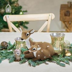 a deer figurine sitting on top of a table next to cups and candles