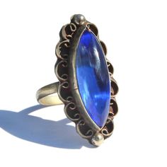 "Vintage Mexican blue glass Alpaca silver ring. Size 8. Long marquise / navette shaped cobalt blue glass cabochon stone bezel set in a decorative frame with filigree and granulation. Stamped \"Mexico\" on reverse side with a zig-zag etching (this was an old method assay offices used to scratch the piece to measure metal content). Such a stunning large statement ring with brilliant color. Acquired from the estate of a Mexican jewelry collector. 1.25\" length and 0.5\" width. Excellent condition." Mexican Blue, Mexican Jewelry, Decorative Frame, Turtle Charm, Vintage Mexican, Frame Decor, Brilliant Colors, Estate Jewelry, Statement Ring