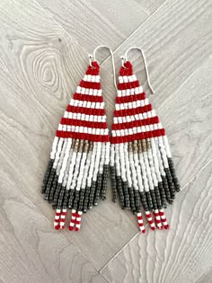 red, white and black beaded earrings on wooden floor with wood planks in the background