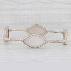 This lovely new bracelet is an authentic Nina Nguyen piece. This bracelet has a retail price of $495. Gem: Natural White Quartz Metal: Sterling Silver Weight: 22.6 Grams  Stamps: 925 nn Style: Bangle Bracelet Closure: Pull Over Inner Circumference: 8 1/4" Width: 15.7 mm - 2.5 mm Each piece is thoroughly examined and refinished as needed by our professional jewelers, graded by our in-house GIA (Gemological Institute of America) Graduate Gemologist, and inspected for quality before being carefully packaged and promptly shipped. [SKU: A3206] Modern Gemstone Bracelets For Anniversary, Luxury Natural Stones Bracelets, Adjustable White Gold Stackable Bracelets, Adjustable Stackable White Gold Bracelets, Elegant Natural Stones Cuff Bracelet, Elegant Natural Stone Cuff Bangle, Elegant Natural Stones Cuff Bangle Bracelet, Elegant Cuff Bracelet With Natural Stones, Elegant Metal Bracelets With Natural Stones