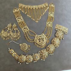 an assortment of gold jewelry is displayed on a table