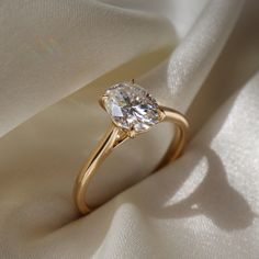 a close up view of a diamond ring on a white cloth