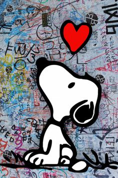 a snoopy dog with a red heart on it's head is sitting in front of graffiti covered walls