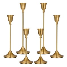 four gold candlesticks on a white background