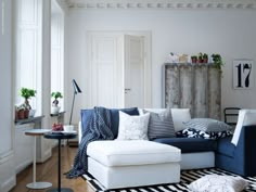 a living room filled with lots of furniture and decor on top of a hard wood floor