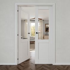 an open door leading to a bedroom with white walls and wood flooring on the side