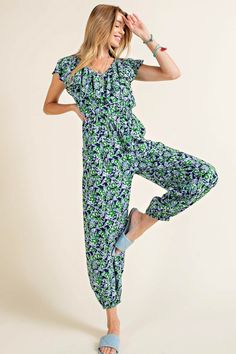 A comfortable jumpsuit with a pop of red and sprinkle of flowers. This jogger style jumpsuit has an elastic waistline, shaping the loose, lightweight fabric. There is a ruffled fabric detail along the neckline and sleeves, and side pockets. Style with sandals for a picnic in the park. Model is 5'10" and wearing her true size Small. Small: Bust 18", Length 54.5" 100% Rayon Casual Printed Jumpsuits And Rompers For Spring, Overall Jumpsuits And Rompers With Elastic Waistband For Loungewear, Casual Printed Relaxed Fit Jumpsuits And Rompers, Printed Casual Relaxed Fit Jumpsuits And Rompers, Casual Relaxed Fit Printed Jumpsuits And Rompers, Casual Floral Print V-neck Jumpsuits And Rompers, Casual Green Floral Print Jumpsuit, Casual Floral Print Jumpsuits And Rompers, Casual Multicolor Jumpsuits And Rompers With Elastic Waistband