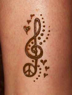 a tattoo on the side of a woman's leg with music notes and hearts