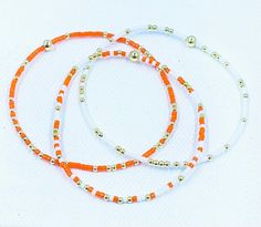 Dainty yet bold, these seed bead bracelets are the kind you'll forget you're wearing - until the next compliment is made, that is. White, Orange miyuki seed beads and 2mm gold filled beads are hand threaded onto high quality stretch cord in a fun-loving design that you'll reach for time and time again. These bracelets are hypoallergenic and will not tarnish! Perfect for Tennesse game day or any occasion! To find your bracelet size measure all the way around your wrist with a flexible tape measure, order 1/2 inch larger for fitted bracelets or 1 inch larger for looser fit bracelets. Xoxo,  Shelly White Jewelry With Gold Beads For Friendship, Orange Heishi Beaded Bracelets With Tiny Beads, White Beaded Bracelets With Tiny Beads For Friendship, White Beaded Bracelets With Gold Beads For Friendship, Handmade Orange Heishi Beads Friendship Bracelets, White Friendship Bracelets With Gold Beads As A Gift, White Friendship Bracelet With Gold Beads As Gift, White Beaded Heishi Friendship Bracelets, White Beaded Bracelets With Gold Beads For Beach