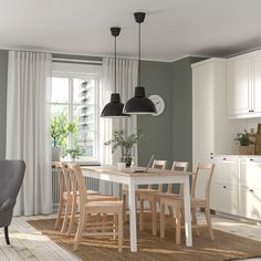 a dining room table and chairs in front of a window