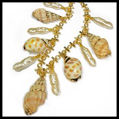 "This classy piece is made with:  ~Hand gold leaf painting ~Bali shells ~Gold novelty chain ~Long faux freshwater  pearls ~16\" length with lobster clasp and adjustment chain." Gold Shell Necklace With Lobster Clasp, Shell-shaped Gold Pearl Necklace With Charm, Gold Shell Jewelry With Pearl Chain, Handmade Gold Shell Pearl Necklace, Gold Shell-shaped Pearl Necklace With Charm, Gold Shell-shaped Necklace With Pearl Chain, Gold Shell Pearl Chain Jewelry, Gold Pearl Charm Necklace In Shell Shape, Gold Shell-shaped Mother Of Pearl Necklace