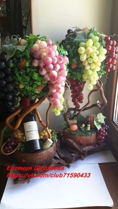 grapes and other fruits are arranged in baskets on a table next to a wine bottle