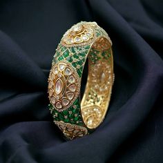 Emerald Polki Bangle, a Sabyasachi-inspired masterpiece. The vibrant Green Kundan stones and Moissanite Polki detailing enhance the regal charm of this bracelet. Crafted with precision, the Uncut Polki Jewelry captures the essence of traditional allure. These high-quality Polki Kada Bangles showcase a blend of sophistication and luxury, making a statement of grace and elegance that complements both traditional and contemporary ensembles. *𝐏𝐑𝐎𝐃𝐔𝐂𝐓 𝐃𝐄𝐓𝐀𝐈𝐋* * Material: Brass * Plating: Gold Plated * Stone: Semi Precious Kundan, Polki & Emerald.  *𝐃𝐈𝐌𝐄𝐍𝐒𝐈𝐎𝐍𝐒* *  Openable *𝐒𝐇𝐈𝐏𝐏𝐈𝐍𝐆 𝐏𝐎𝐋𝐈𝐂𝐘* * Shipping: worldwide from India. * Free shipping: All our products have a free standard shipping policy. So, choosing to shop with us is always free! * The average standa Traditional Luxury Openable Bangle, Luxury Kundan Openable Bangle, Luxury Traditional Kundan Bracelets, Polki Bangles Uncut Diamond, Polki Kada, Kundan Kada, Polki Bracelet, Kada Bangles, Gold Kada