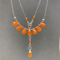 Nice little orange necklace ! Delicate semi-translucent Carnelian necklace with a beautiful orange color, sterling silver, fine silver, Hill Tribe silver, rolo chain, natural gemstone, July birthstone ! I handcrafted this beautiful semi-translucent Carnelian necklace in a beautiful orange color. The central part is composed of 7 faceted Carnelian drops intercaleted with fine silver rondelle of Hill Tribe silver and is connected to a sterling silver rolo chain whose links are 1.5 mm wide. Hand fo Carnelian Necklace Aesthetic, Orange Necklace, Carnelian Necklace, Pretty Beads, Hill Tribe Silver, Pretty Jewelry, July Birthstone, Silver Spring, Rolo Chain