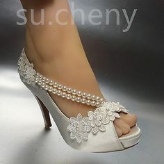 a woman's foot with pearls on it and a white high heeled shoe