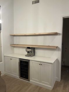 an empty room with some shelves on the wall