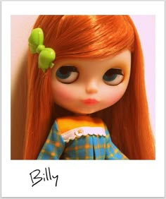 a doll with long red hair wearing a green bow