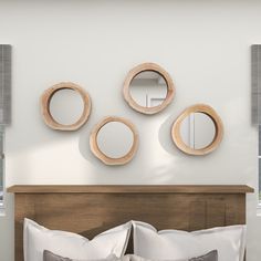 three round mirrors mounted on the wall above a bed