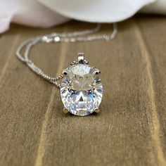 "The pendant pictured is a simulated diamond #6760 -Approximate total carat weight: approx. 3.00ctw diamond equivalent -Center Stone Size: 10x8mm - approx. 3.00ct diamond equivalent -Center Stone Shape: oval -Gem Type: simulated diamond -Stone Clarity: VVS1 -Stone Color: D -Moh's Scale: 8.5 hardness -Metal Type and Purity: 14k white gold -Setting: 4 prong basket head -Chain: 18\" delicate 14k gold chain / heavier option with lobster claw available (use dropdown to select) -Country of Manufacturi Oval Crystal Necklace With Diamond Accents, Oval Crystal Necklaces With Diamond Accents, Silver Classic Solitaire Necklace With Oval Pendant, Silver Solitaire Diamond Cut Oval Pendant Necklace, Classic Silver Solitaire Necklace With Oval Pendant, Oval Solitaire Necklace In Silver With Prong Setting, Formal Oval Solitaire Necklace In Sterling Silver, Oval Diamond Cut Pendant Jewelry For Gift, Gift Diamond Cut Oval Pendant Jewelry