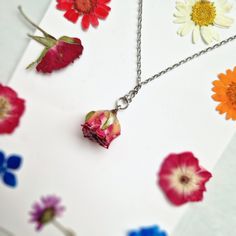 This Pink Rose necklace is a beautiful and unique piece of jewellery that features a real pink rose covered in resin. As a symbol of femininity, grace, and fresh love, this necklace is the perfect gift for a loved one on special occasions like Birthdays and Valentine's Day. The dried flower pendant is around 2 cm in size and hangs from a stylish silver chain that measures approximately 21 cm in length. Please note that as each piece is unique, the size may vary slightly due to natural variations Dainty Flower-shaped Rose Jewelry, Dainty Rose Flower Jewelry, Dainty Flower Shaped Rose Jewelry, Rose Flower Charm Necklace For Mother's Day, Rose Necklace With Flower Charm For Mother's Day, Delicate Rose Jewelry With Flower Charm, Delicate Rose Flower Jewelry, Rose Flower Pendant Charm Necklace, Rose Flower Pendant Jewelry For Her