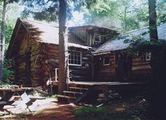 an old log cabin in the woods surrounded by trees