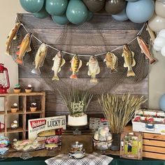 a party with balloons and decorations on the wall, including fish hanging from clothes line