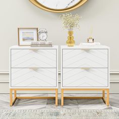 two white dressers with gold handles in front of a clock