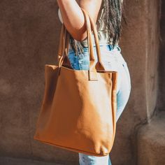 A soft, unstructured, leather tote bag that carries it all—for work and play, at home and while you travel. Featuring a deep, roomy interior for all your daily necessities, a large wall pocket, and thick straps so you can feel confident carrying anything and everything. Premium veg-tanned sheep leather 16" wide and 14" tall Interior wall pocket will fit a 13" laptop Handcrafted and hand-stitched Classic Leather Tote, Daily Necessities, Sheep Leather, Leather Conditioner, Interior Wall, Wall Pockets, Women Supporting Women, Classic Leather, Feel Confident