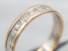 a gold and silver wedding band with white diamonds