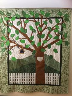 a quilted tree with leaves and a heart hanging from it's center piece