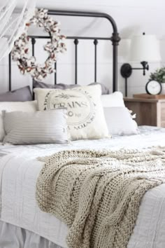 a white bed topped with lots of pillows and blankets