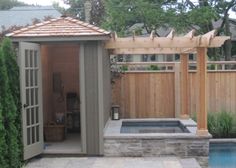 an outdoor hot tub in the middle of a backyard with a wooden fence around it