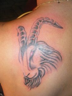 a close up of a tattoo on the back of a woman's upper body