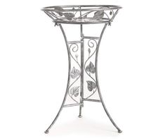 a metal plant stand with butterflies on it's sides and a glass bowl in the center