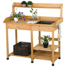 a wooden workbench with plants and flowers on the top shelf next to it