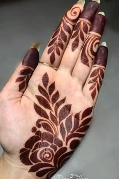 a woman's hand with henna tattoos on it