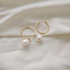 An everyday minimalistic hoop. This earrings is perfect for all day wear and is perfect for the gym, going out, or just a casual day. A classic simple gold hoop with a fresh water pearl.  D E T A I L S - 15 mm 18k gold plated hoop. - One freshwater pearl. These pearls are genuine and real, appearance with vary slightly! Freshwater pearls are high quality and iridescent. Each pearl will vary in shape.  - Earring hoop is gentle on the ears and feels secure.  - Comfortable to wear.  ∙ EXTRAS  - Handcrafted with a lot of love.  - All of my jewelry arrives tightly wrapped.  - If this is a special gift or if you would like a customization just let me know in the message box at checkout.  ∙ MY SHOP Check out more of my pieces - https://www.etsy.com/shop/ashlikitta?ref=simple-shop-header-name&list Cheap Elegant Small Hoop Pearl Earrings, Bridesmaid Earrings Gold Simple, Cheap Hoop Earrings With Pearl Charm For Women, Hoop Pearl Earrings, Simple Gold Earrings, Bridesmaid Earrings Gold, Earring Hoop, Earrings Everyday, Gold Dangle Earrings