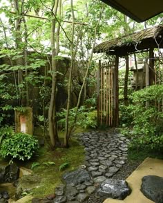 an outdoor area with rocks and trees in the background, along with a gazebo