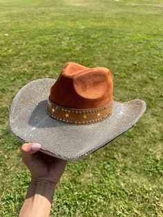 Brown print hat with champagne gold  rhinestones on the top brim. Silver tiny stars on the bottom and some around the crown brim  This is one size fits most, there's a drawstring to adjust sizing.  ships in 2 business days! Stunning in person  Perfect for Halloween , Barbie costume, Coachella , stagecoach, Nashville, country concerts, bachelorette parties, brides, weddings Please note that the hats are handmade and may have some variances and blemishes. If any, they are very minor . The hats might have a bit of "stickiness" from the glue setting the rhinestones, this will improve over time. Adjustable Gold Hat With Rhinestones, Gold Adjustable Hats With Rhinestones, Gold Fedora Hat For Rodeo, Gold Short Brim Hats For Country Events, Gold Brimmed Hat For Rodeo, Western Gold Hat Bands For Party, Gold Western Fedora Hat, Gold Fedora Western Hat, Western Style Gold Hat Bands For Parties