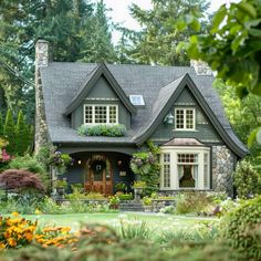 a house in the middle of some trees and flowers