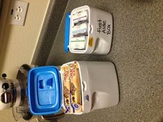 two coolers sitting on top of a counter next to a blender