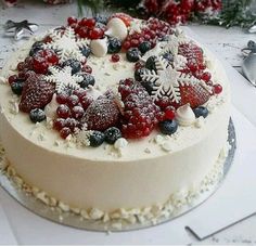 a white cake with berries and snowflakes on it