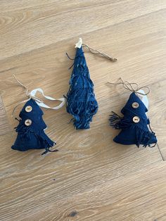 three small blue christmas trees are on the floor next to some twine needles and string