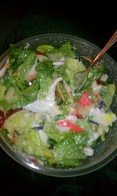 a salad with lettuce and tomatoes in a glass bowl