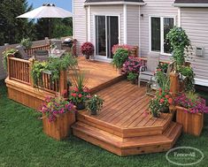 a wooden deck surrounded by potted plants and flowers