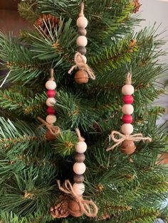 an ornament hanging from the top of a christmas tree with red, white and brown beads