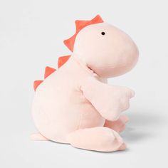 a pink dinosaur stuffed animal sitting on top of a white surface