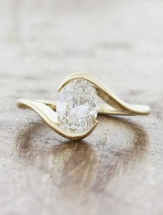 a close up of a ring with a diamond in it on a wooden table top